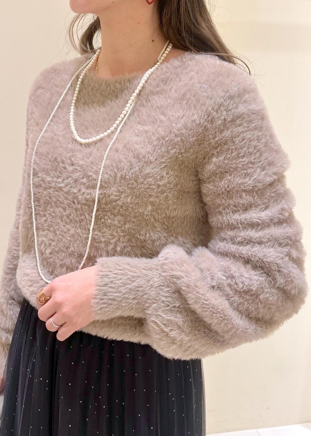 ホワイト系のショルダーバッグ、ブラック系のブーツ、ブラック系のスカートを着用したレディースの冬コーディネートの5枚目の写真