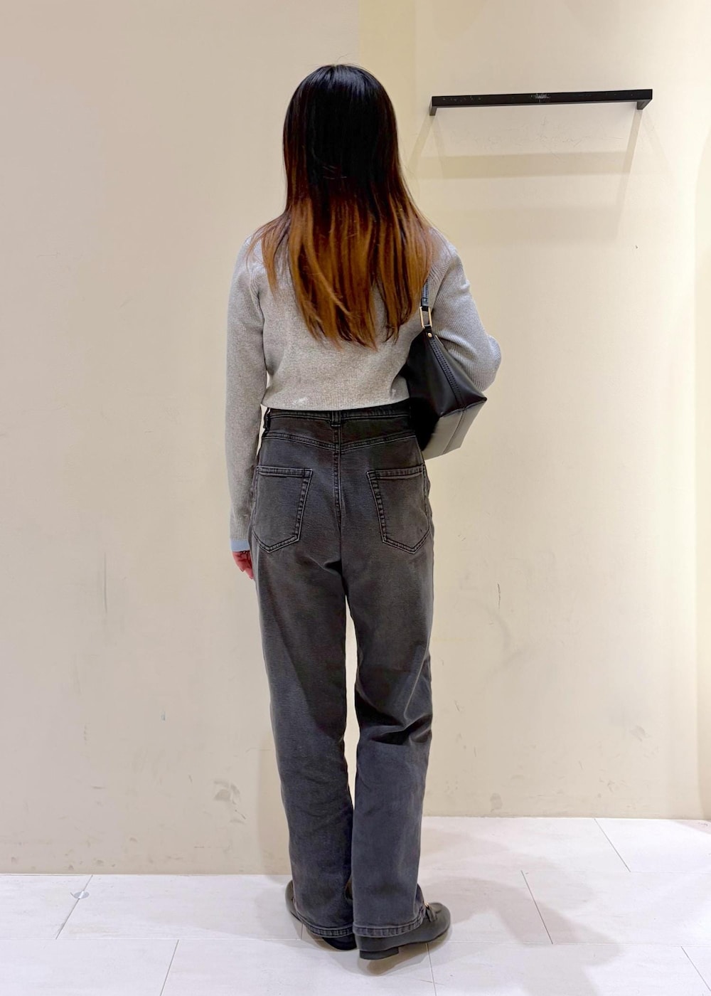 ブラック系のショルダーバッグ、ブラック系のローファー、グレー系のニット/セーターを着用したレディースの冬コーディネートの3枚目の写真