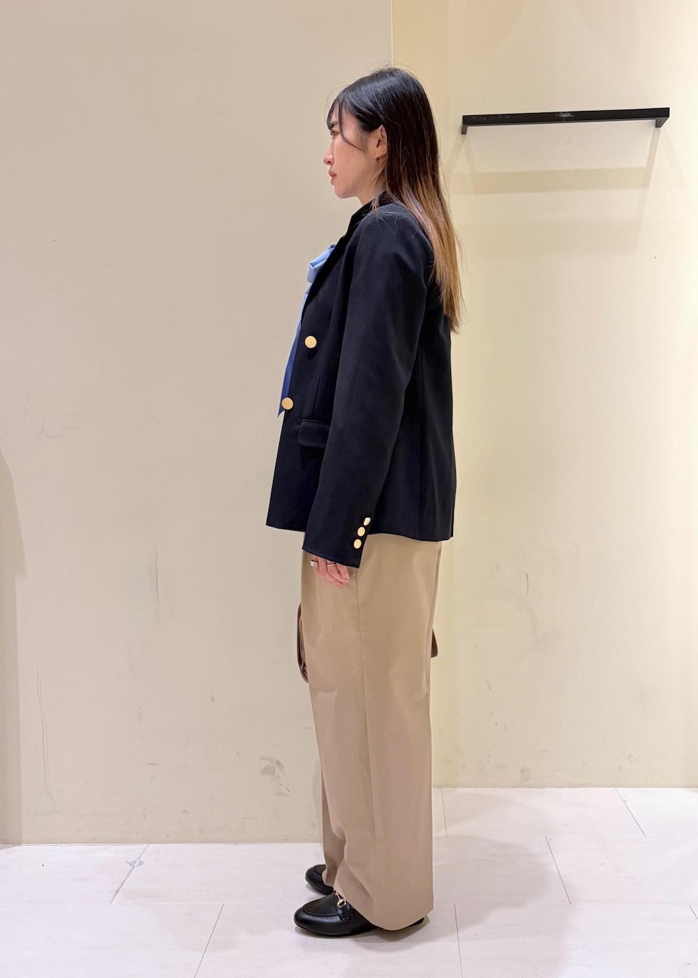 ブラック系のローファー、ブラウン系のボストンバッグ、ブルー系のテーラードジャケットを着用したレディースの冬コーディネートの2枚目の写真