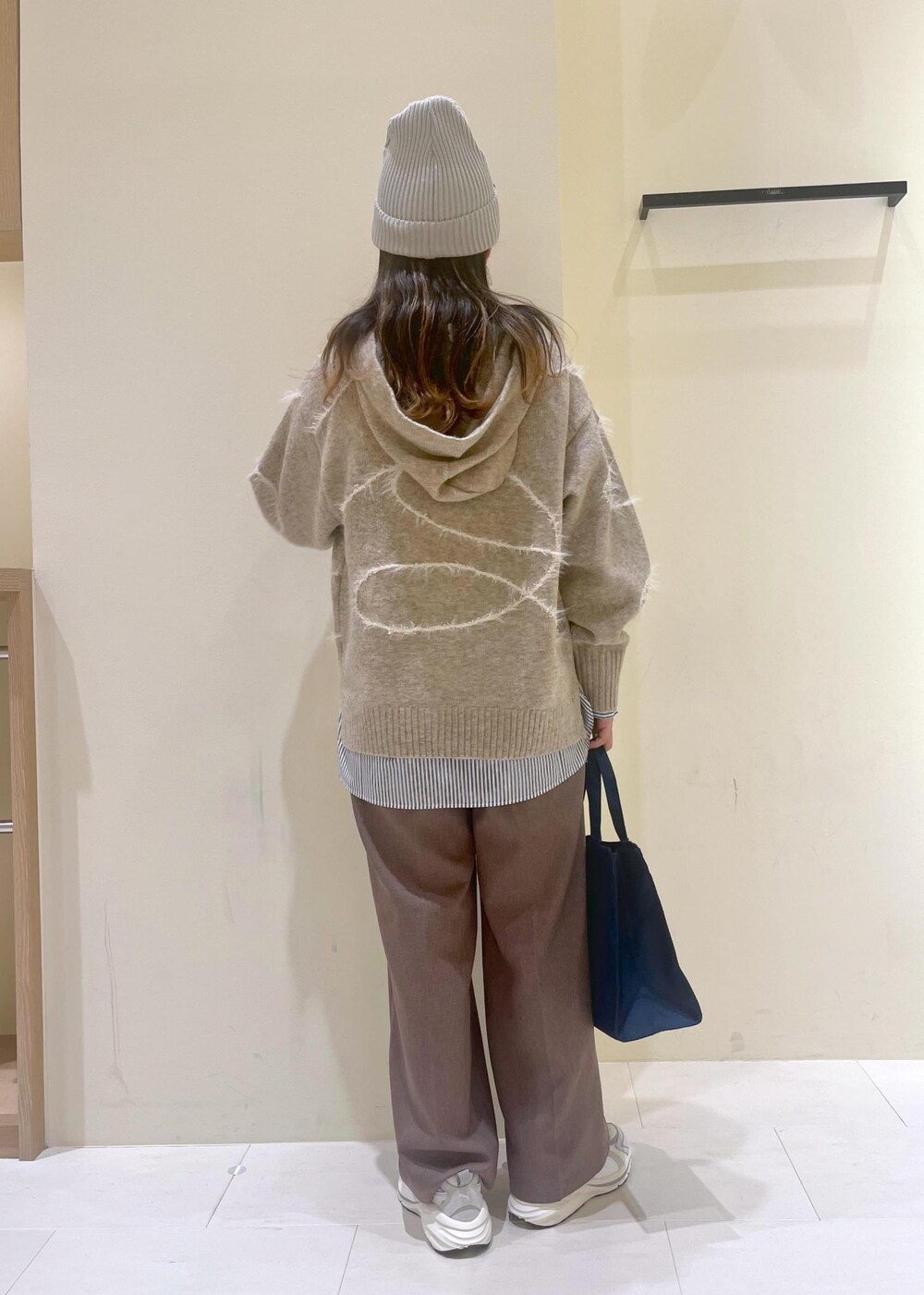 ベージュ系のスラックス、ブルー系のシャツ/ブラウス、ベージュ系のパーカーを着用したレディースの秋コーディネートの3枚目の写真