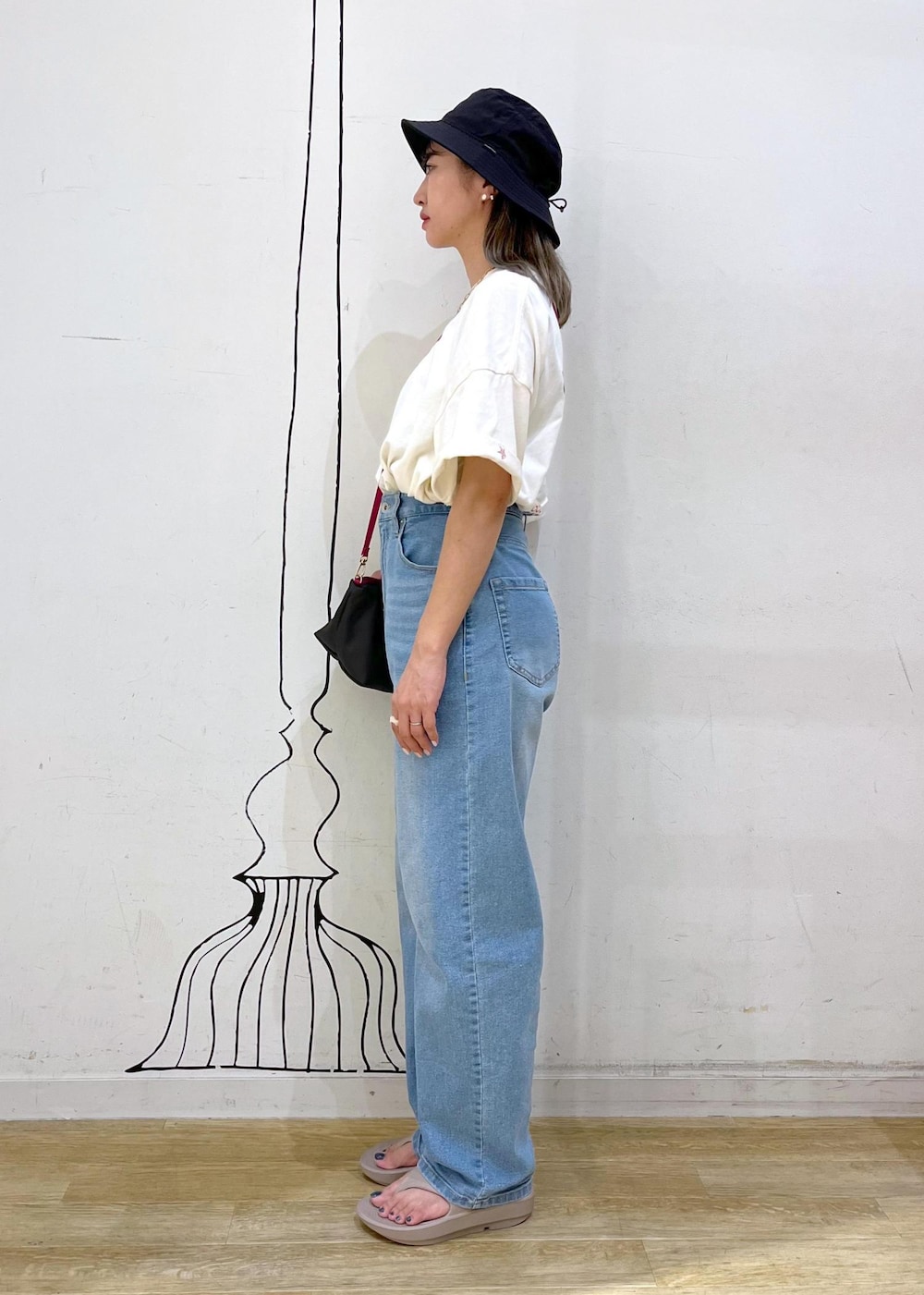 ホワイト系のTシャツ/カットソー、ブルー系のデニムパンツ、グレー系のショルダーバッグを着用したレディースの夏コーディネートの3枚目の写真