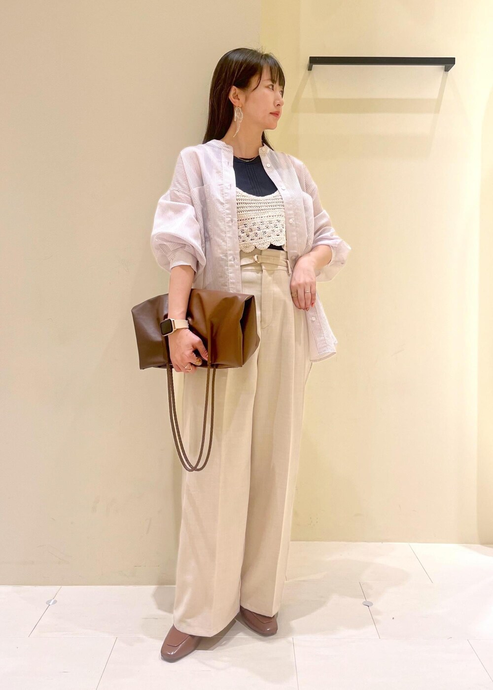 ブラック系のタンクトップ、ブラウン系のトートバッグ、イエロー系のローファーを着用したレディースの春コーディネートの3枚目の写真