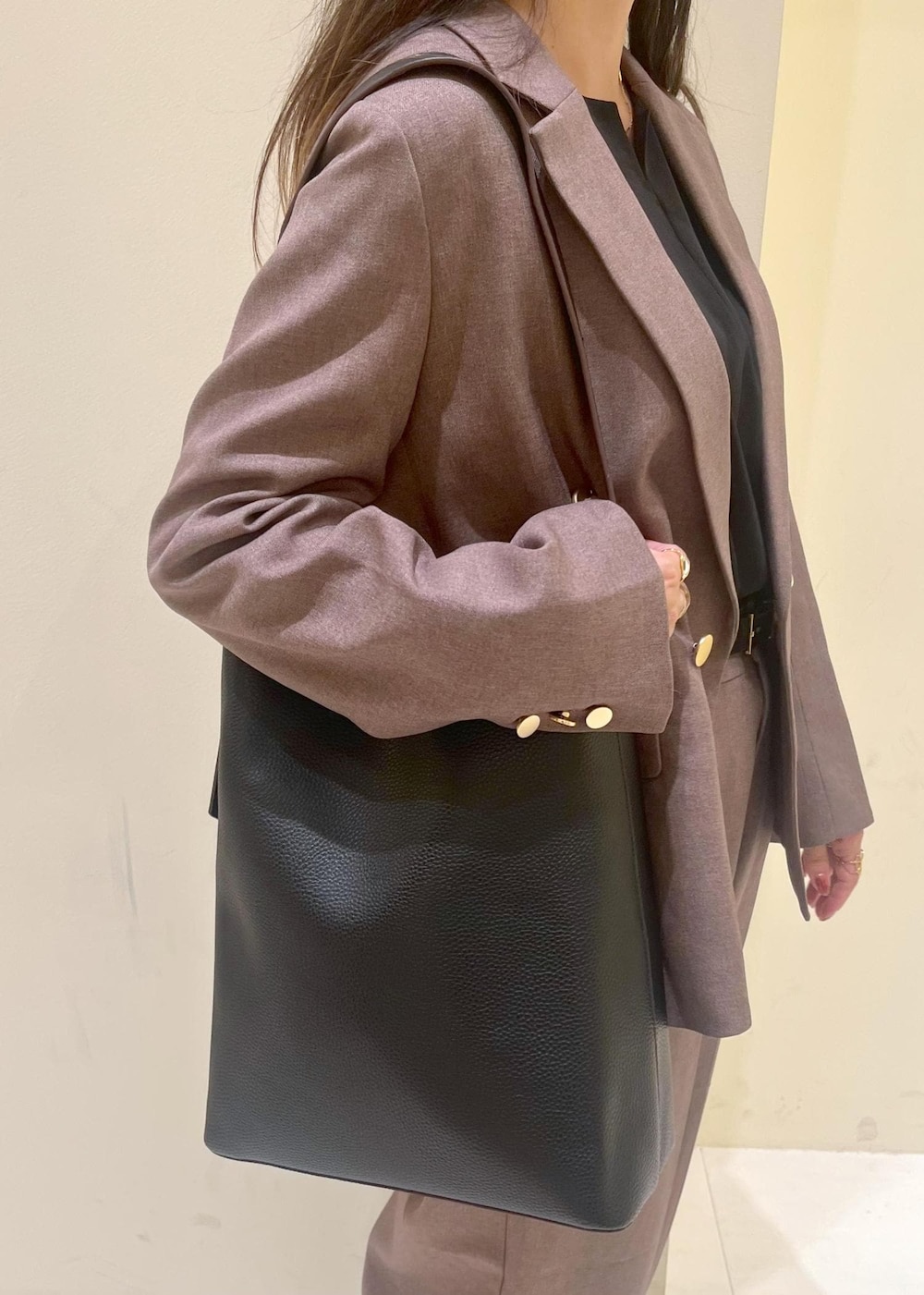 ブラック系のショルダーバッグ、ブラック系のシャツ/ブラウス、ベージュ系のテーラードジャケットを着用したレディースの秋コーディネートの8枚目の写真