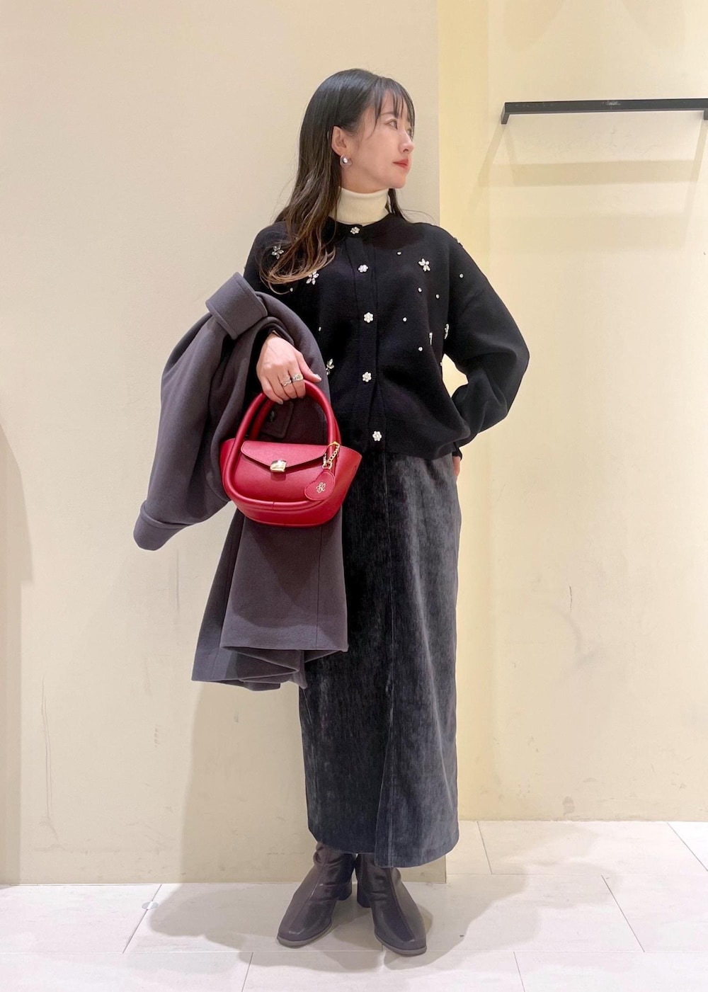 ホワイト系のニット/セーター、グレー系のチェスターコート、レッド系のショルダーバッグを着用したレディースの冬コーディネートの10枚目の写真