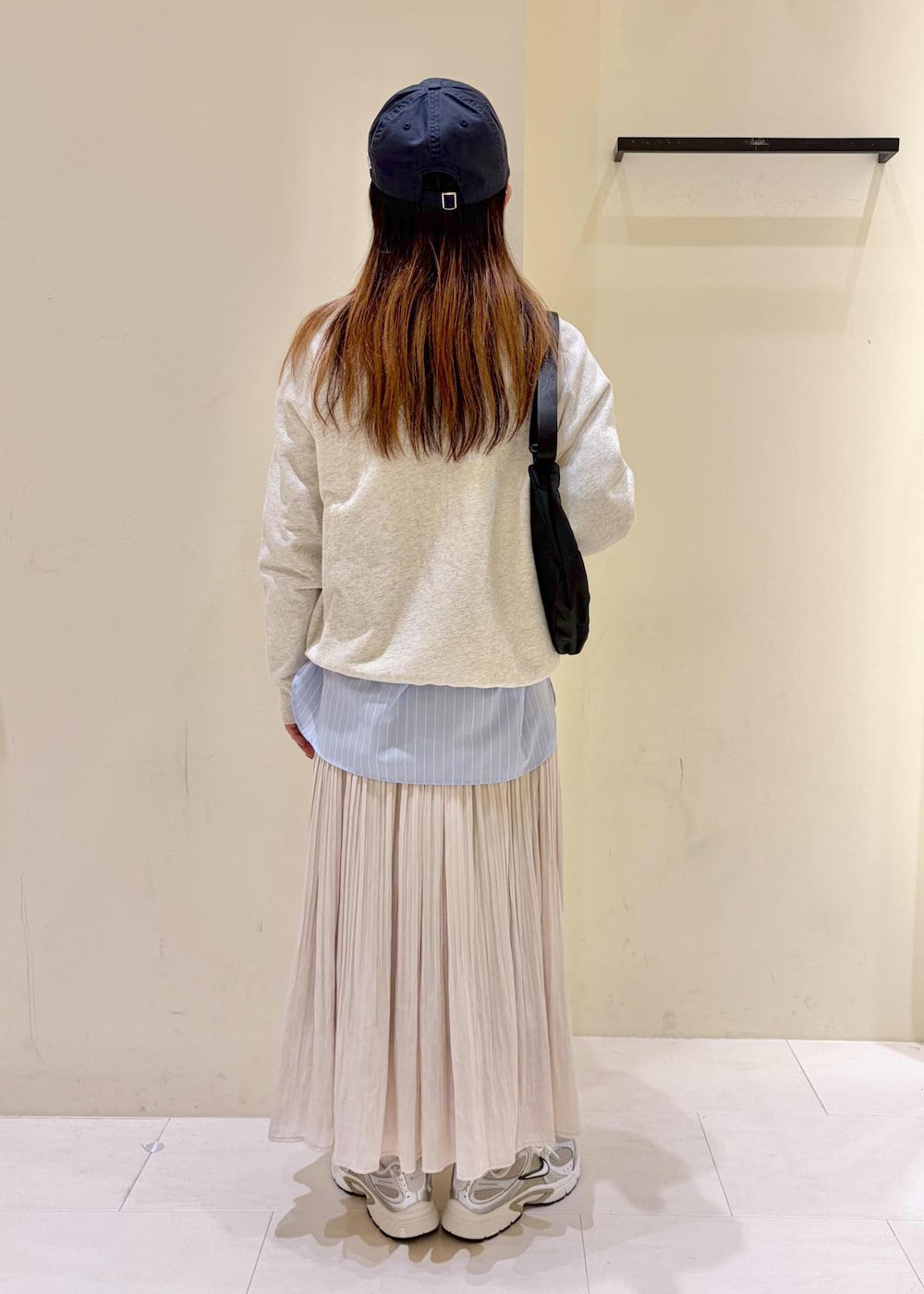 ホワイト系のスウェット、ブルー系のシャツ/ブラウス、ベージュ系のスカートを着用したレディースの冬コーディネートの3枚目の写真