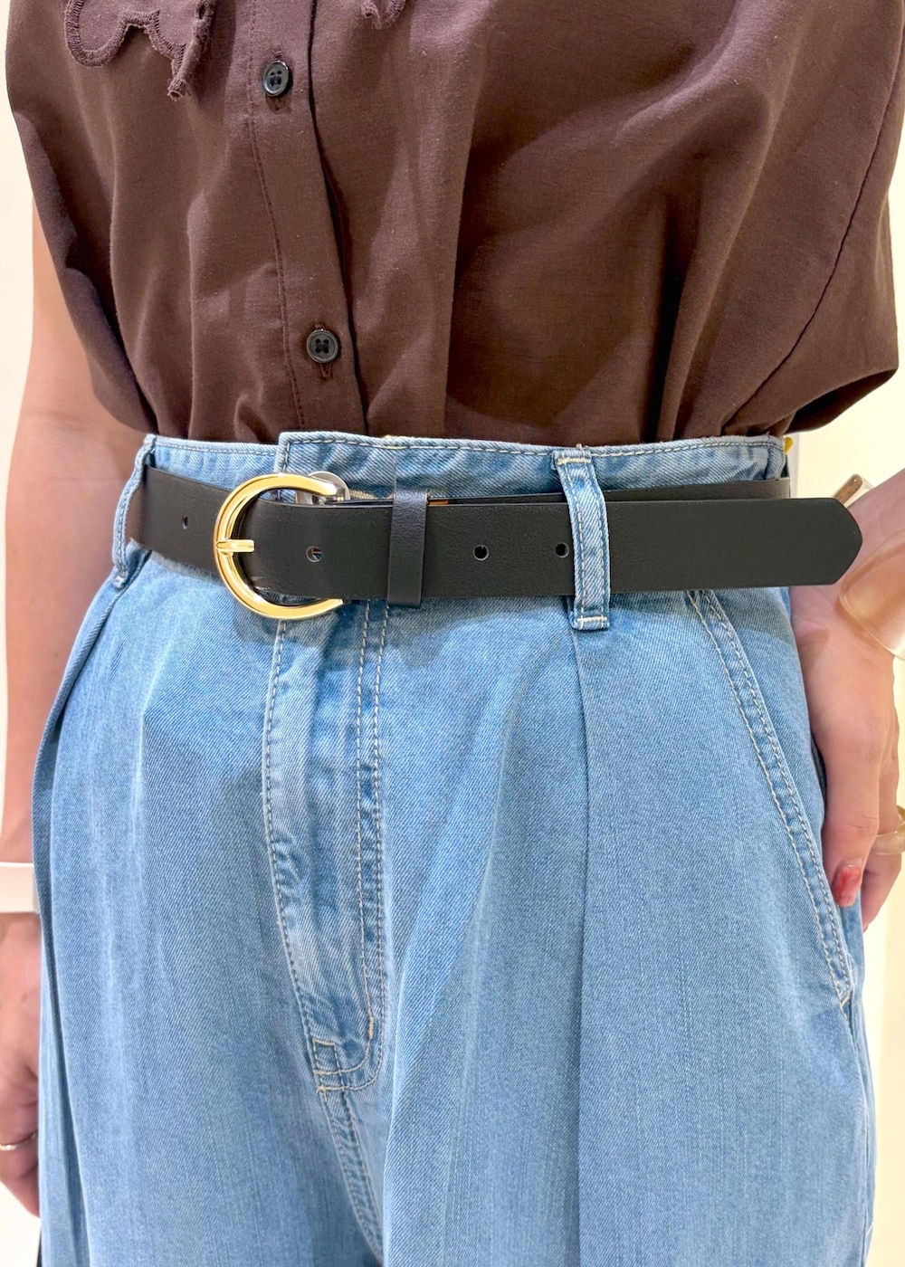 ブラック系のハンドバッグ、ブルー系のデニムパンツ、ブラック系のサンダルを着用したレディースの夏コーディネートの7枚目の写真
