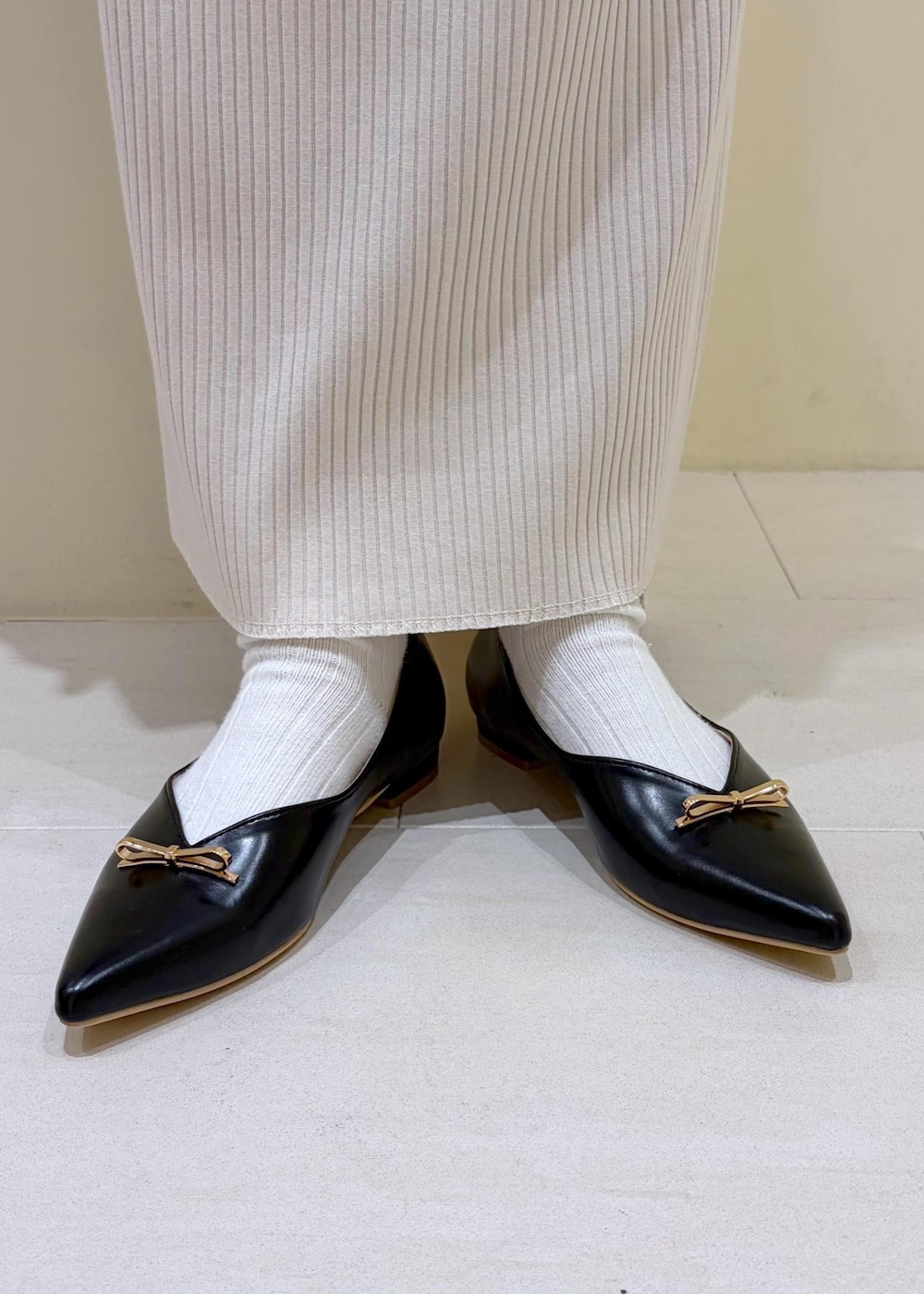 ブラック系のショルダーバッグ、ブラック系のパンプス、ホワイト系のスカートを着用したレディースの春コーディネートの10枚目の写真