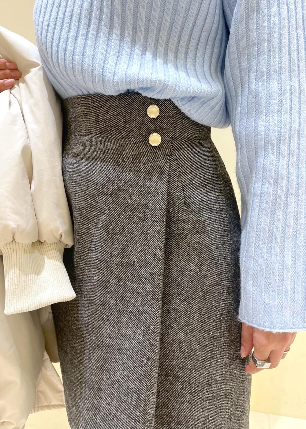 ブラック系のブーツ、ブラウン系のショルダーバッグ、ブルー系のニット/セーターを着用したレディースの冬コーディネートの6枚目の写真