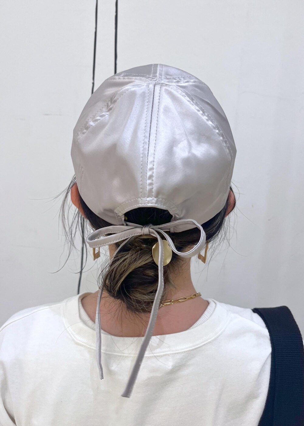 ブラック系のトートバッグ、ブラック系のバレエシューズ、ホワイト系のワンピースを着用したレディースの夏コーディネートの5枚目の写真