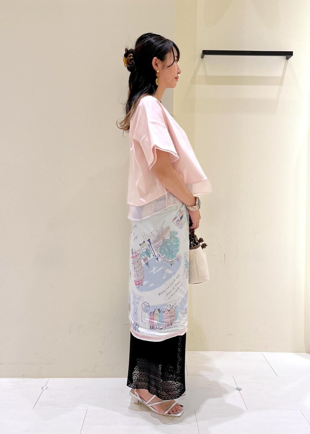 シルバー系のサンダル、ブラウン系のトートバッグ、ブラック系のスカートを着用したレディースの夏コーディネートの3枚目の写真