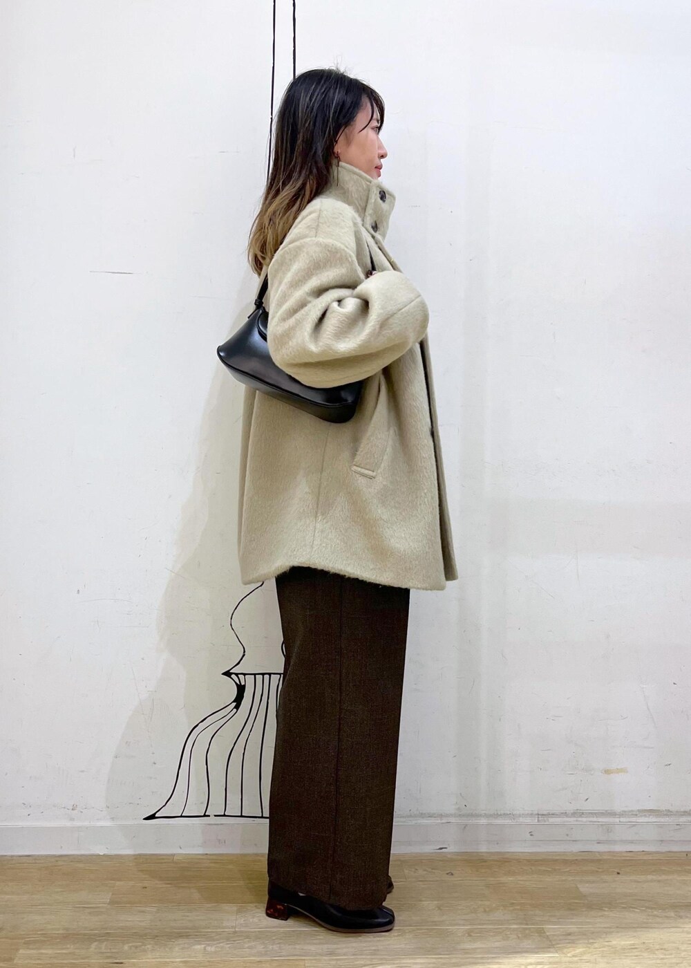 ホワイト系のニット/セーター、グリーン系のその他アウター、ブラウン系のその他パンツを着用したレディースの冬コーディネートの2枚目の写真