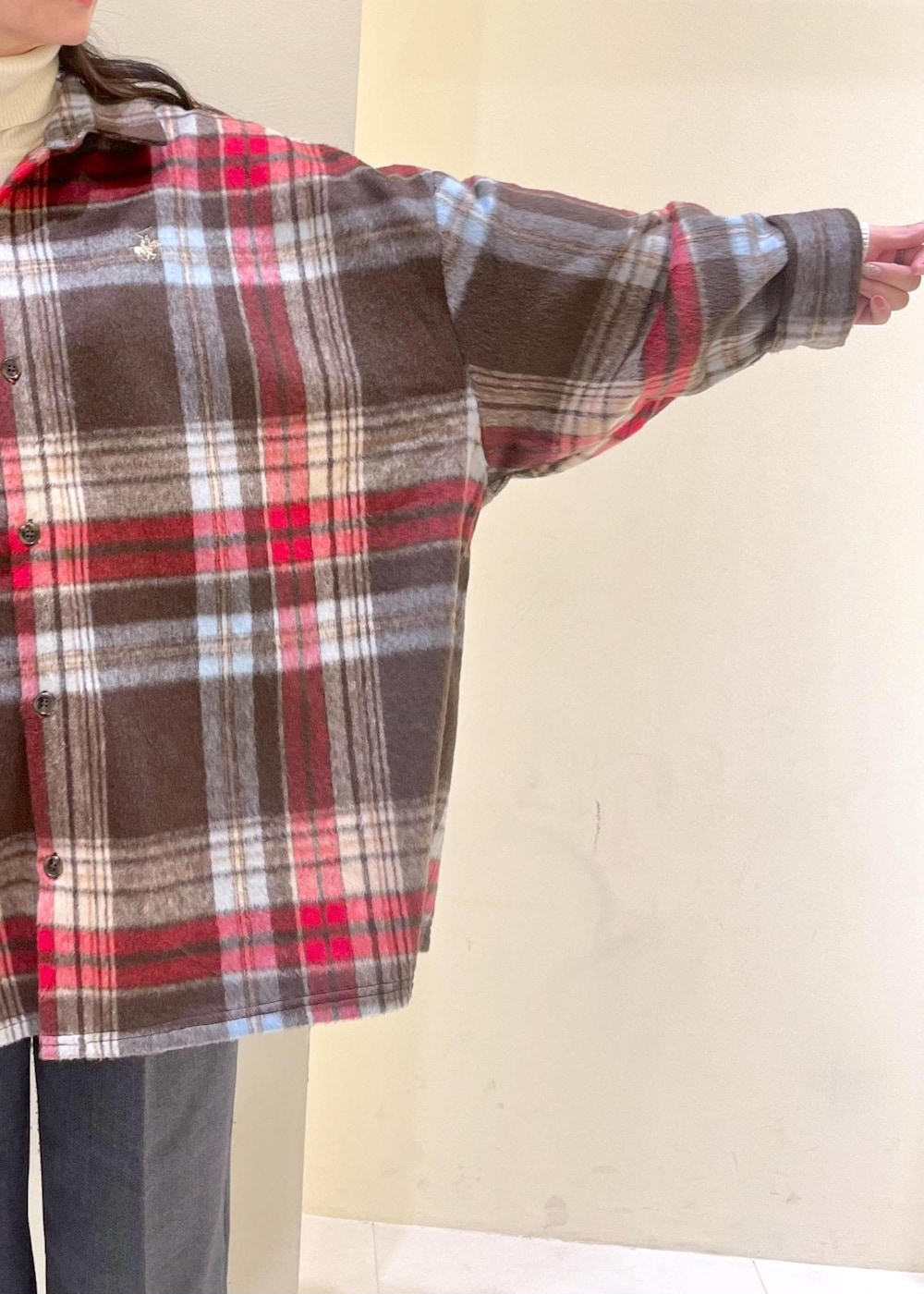 ブラウン系のシャツ/ブラウス、ホワイト系のニット/セーター、グレー系のスラックスを着用したレディースの冬コーディネートの7枚目の写真