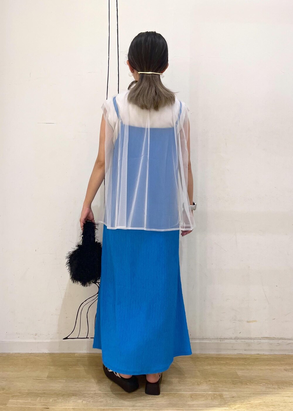 ホワイト系のサンダル、ブルー系のワンピース、ブラック系のハンドバッグを着用したレディースの夏コーディネートの3枚目の写真