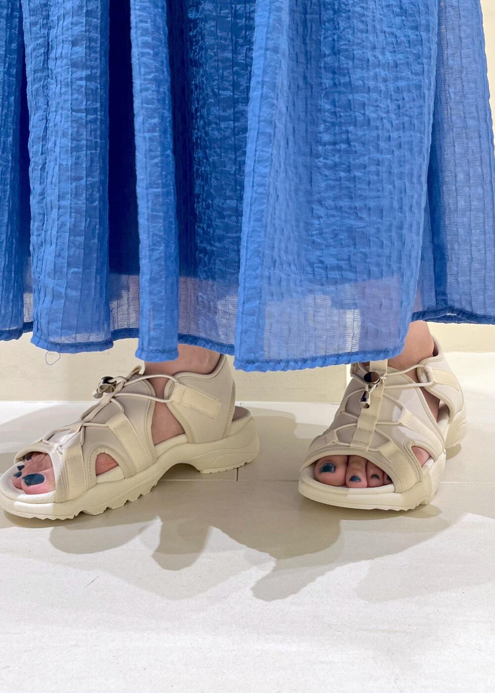 ブラック系のTシャツ/カットソー、ホワイト系のサンダル、ベージュ系のバックパック/リュックを着用したレディースの夏コーディネートの10枚目の写真