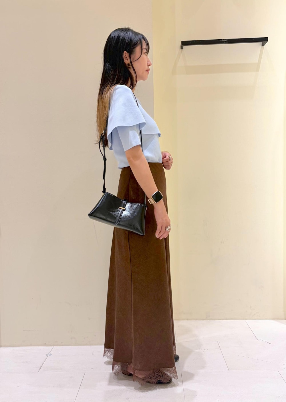 ブラック系のパンプス、ブルー系のニット/セーター、ブラウン系のスカートを着用したレディースの夏コーディネートの2枚目の写真