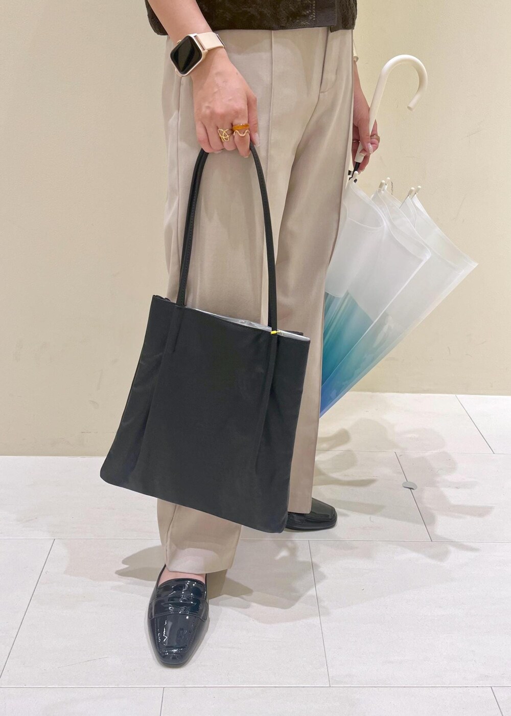 ブラック系のレインシューズ、ブラック系のトートバッグ、ベージュ系のその他パンツを着用したレディースの夏コーディネートの8枚目の写真