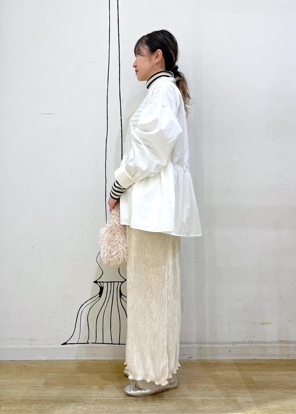 ベージュ系のハンドバッグ、ホワイト系のニット/セーター、シルバー系のバレエシューズを着用したレディースの冬コーディネートの4枚目の写真