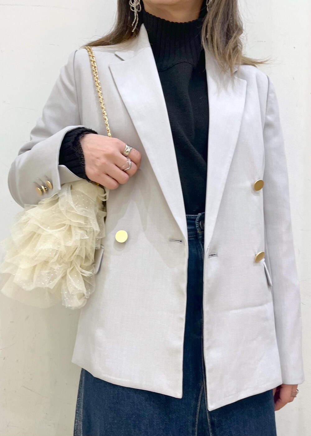 ブラック系のニット/セーター、ブラック系のニット/セーター、ブルー系のデニムスカートを着用したレディースの冬コーディネートの4枚目の写真