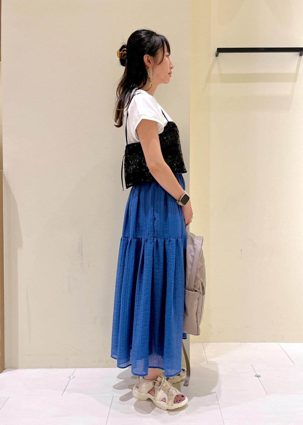 ブラック系のTシャツ/カットソー、ホワイト系のサンダル、ベージュ系のバックパック/リュックを着用したレディースの夏コーディネートの2枚目の写真