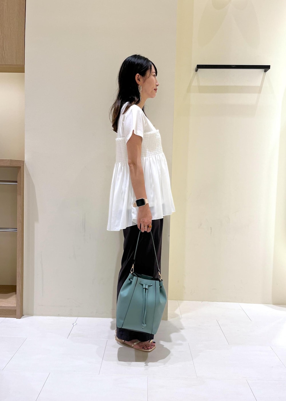 ブルー系のショルダーバッグ、グレー系のその他パンツ、ゴールド系のサンダルを着用したレディースの夏コーディネートの3枚目の写真