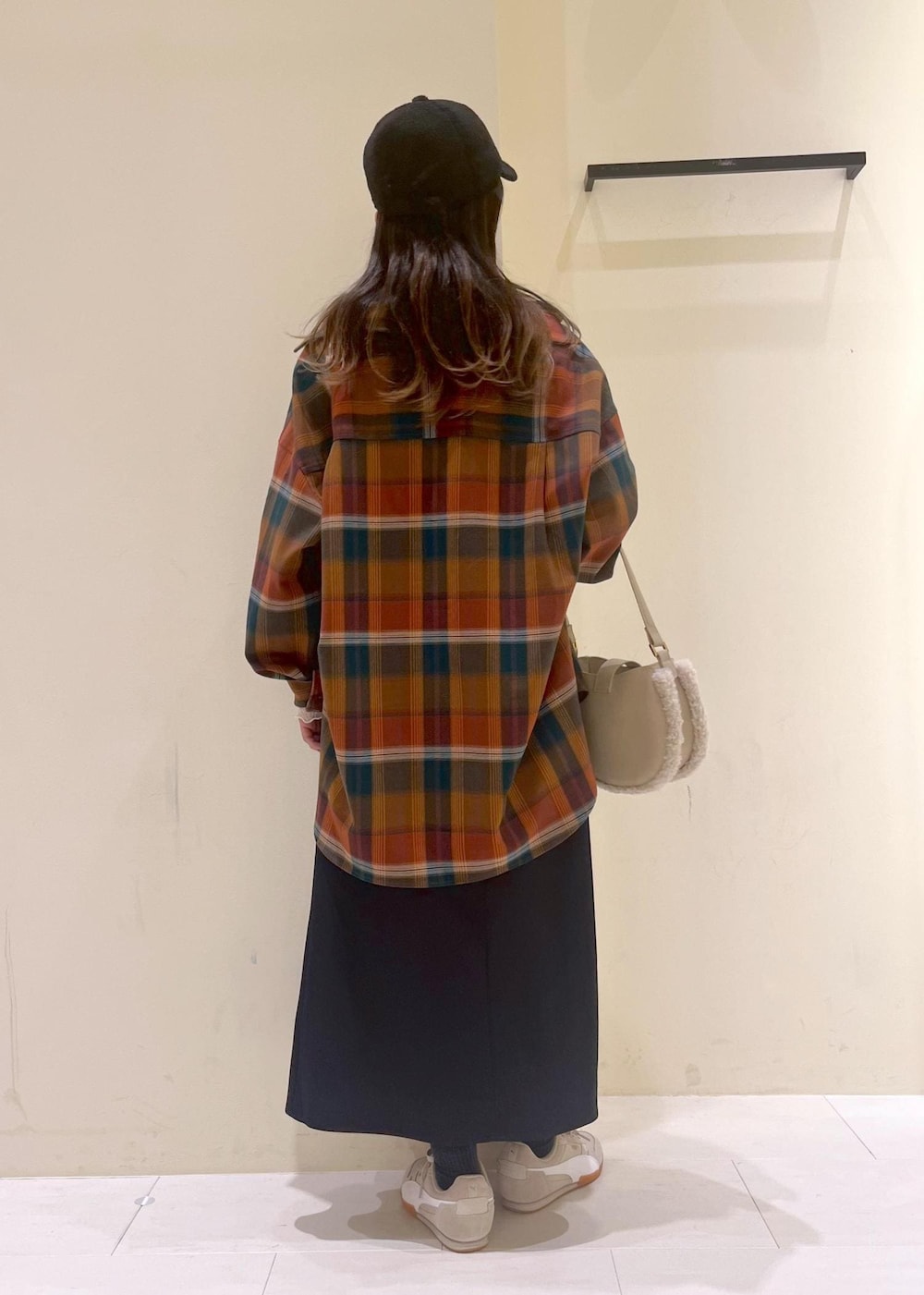 ブルー系のスカート、オレンジ系のシャツ/ブラウス、ホワイト系のTシャツ/カットソーを着用したレディースの秋コーディネートの3枚目の写真