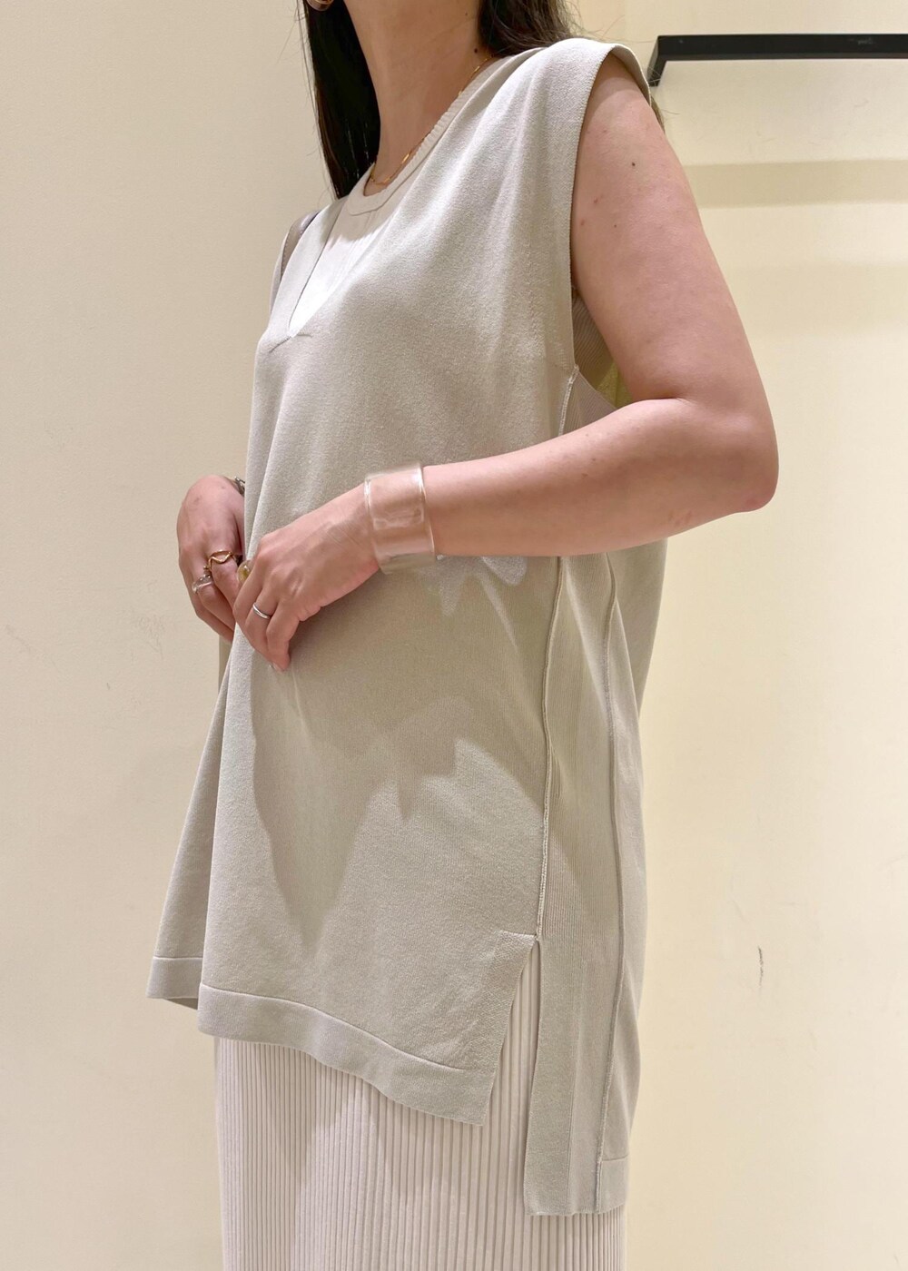 ベージュ系のタンクトップ、シルバー系のサンダル、ベージュ系のショルダーバッグを着用したレディースの夏コーディネートの5枚目の写真