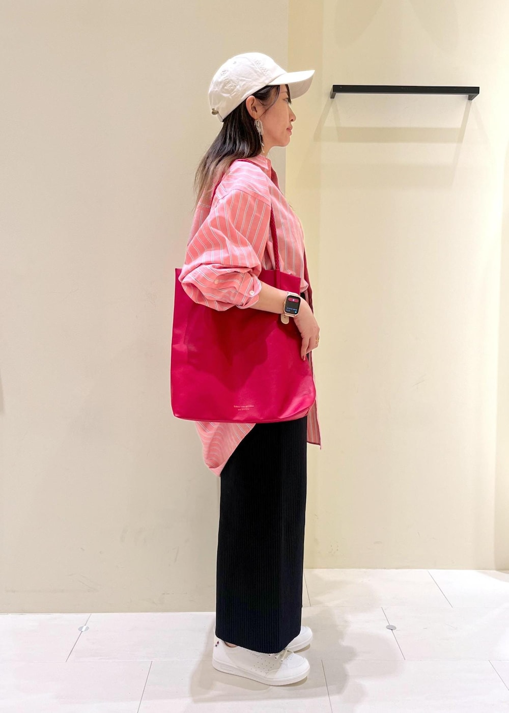 レッド系のトートバッグ、ブラック系のスカート、レッド系のシャツ/ブラウスを着用したレディースの春コーディネートの2枚目の写真