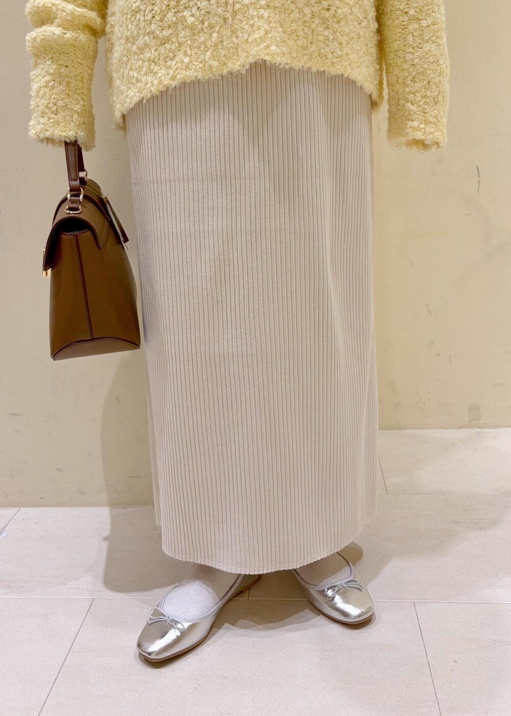 シルバー系のバレエシューズ、ホワイト系のシャツ/ブラウス、イエロー系のニット/セーターを着用したレディースの冬コーディネートの7枚目の写真