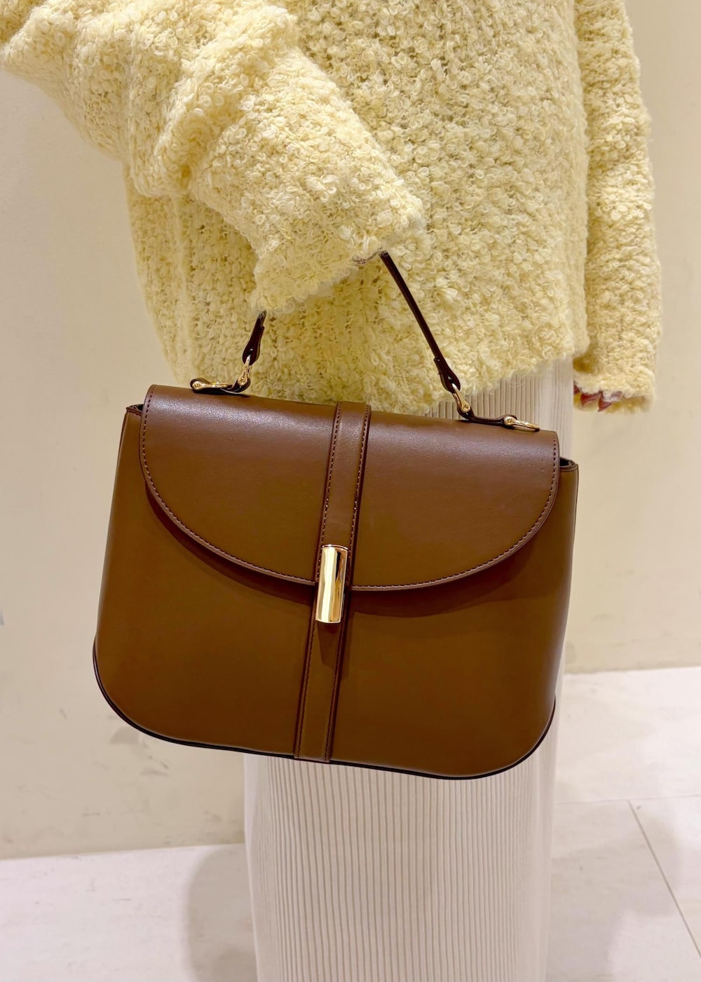 シルバー系のバレエシューズ、ホワイト系のシャツ/ブラウス、イエロー系のニット/セーターを着用したレディースの冬コーディネートの9枚目の写真