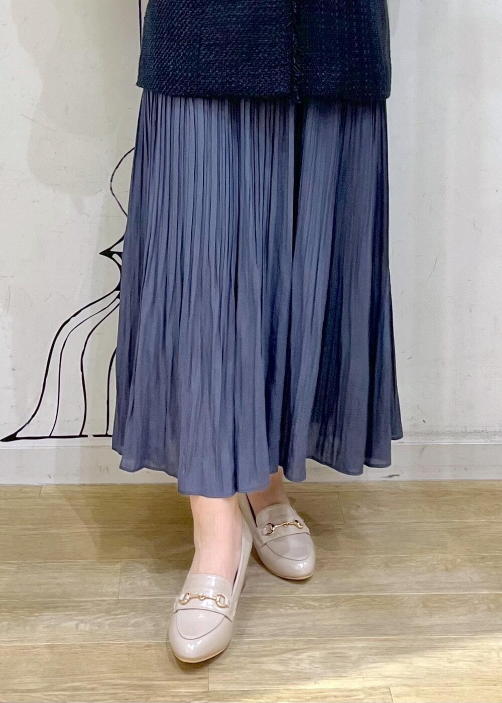 ブルー系のスカート、ベージュ系のローファー、ホワイト系のハンドバッグを着用したレディースの冬コーディネートの7枚目の写真