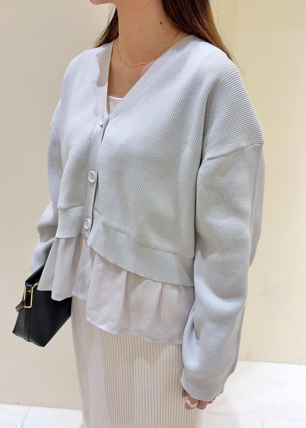 ブラック系のショルダーバッグ、ブラック系のパンプス、ホワイト系のスカートを着用したレディースの春コーディネートの4枚目の写真