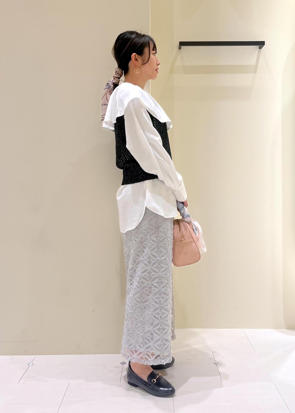 ブラック系のローファー、グレー系のスカート、ホワイト系のシャツ/ブラウスを着用したレディースの春コーディネートの3枚目の写真