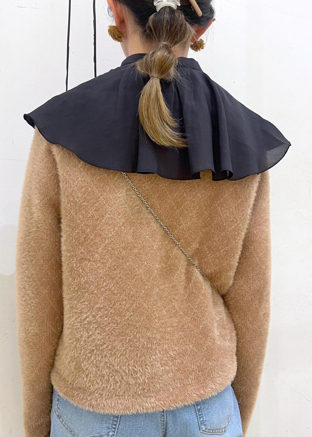 ブルー系のデニムパンツ、イエロー系のカーディガン/ボレロ、ホワイト系のショルダーバッグを着用したレディースの秋コーディネートの7枚目の写真