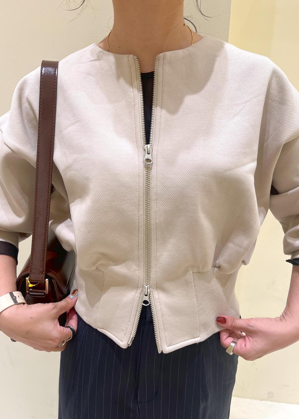 レッド系のショルダーバッグ、ブルー系のその他パンツ、ブラック系のTシャツ/カットソーを着用したレディースの秋コーディネートの5枚目の写真