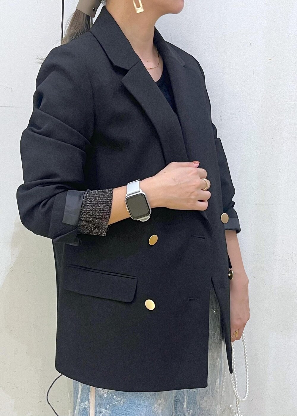 ホワイト系のスカート、ブラック系のニット/セーター、ブラック系のテーラードジャケットを着用したレディースの秋コーディネートの7枚目の写真