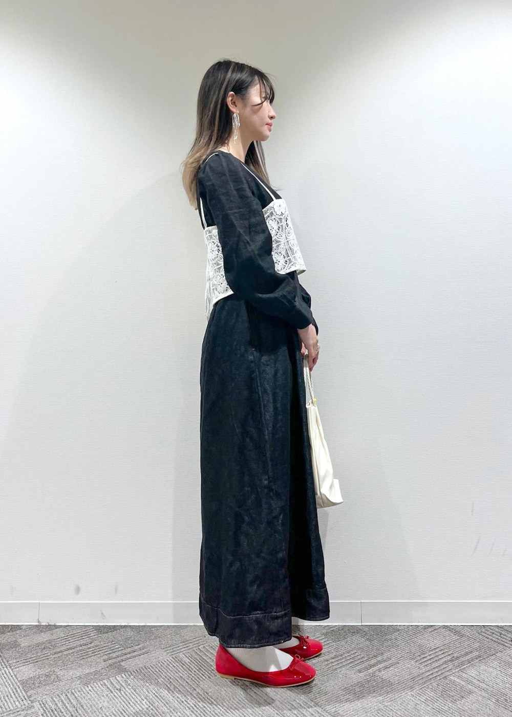 ホワイト系のトートバッグ、ホワイト系のキャミソール、レッド系のバレエシューズを着用したレディースの冬コーディネートの3枚目の写真