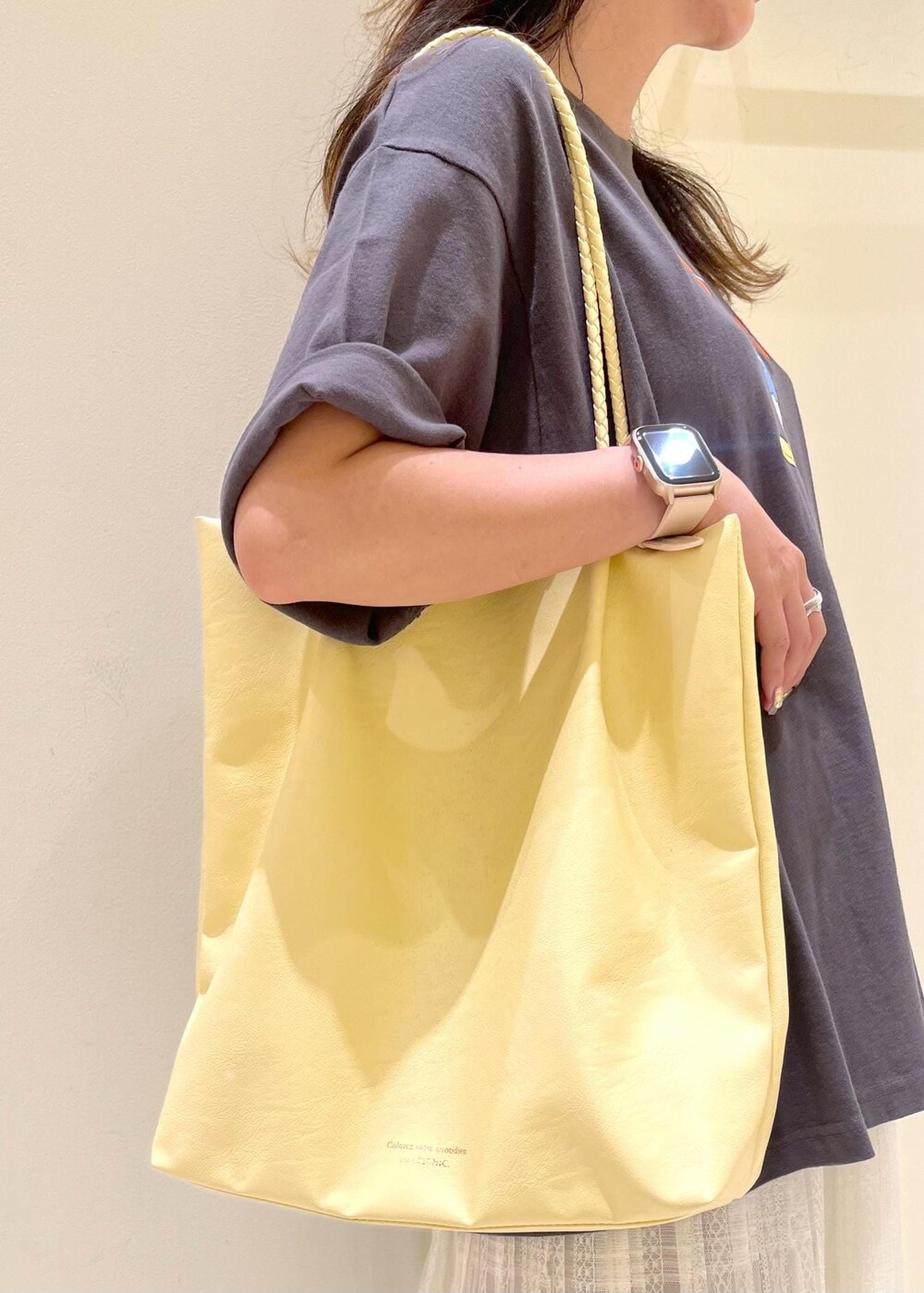 イエロー系のトートバッグ、ホワイト系のスカート、ベージュ系のその他パンツを着用したレディースの夏コーディネートの8枚目の写真