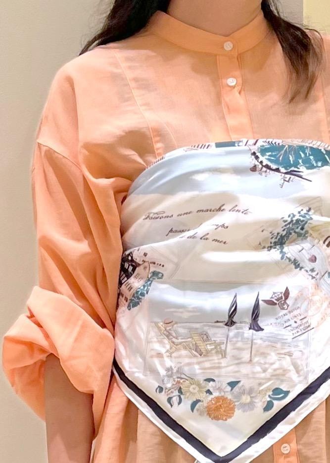 オレンジ系のシャツ/ブラウス、シルバー系のパンプス、ブラック系のトートバッグを着用したレディースの夏コーディネートの5枚目の写真