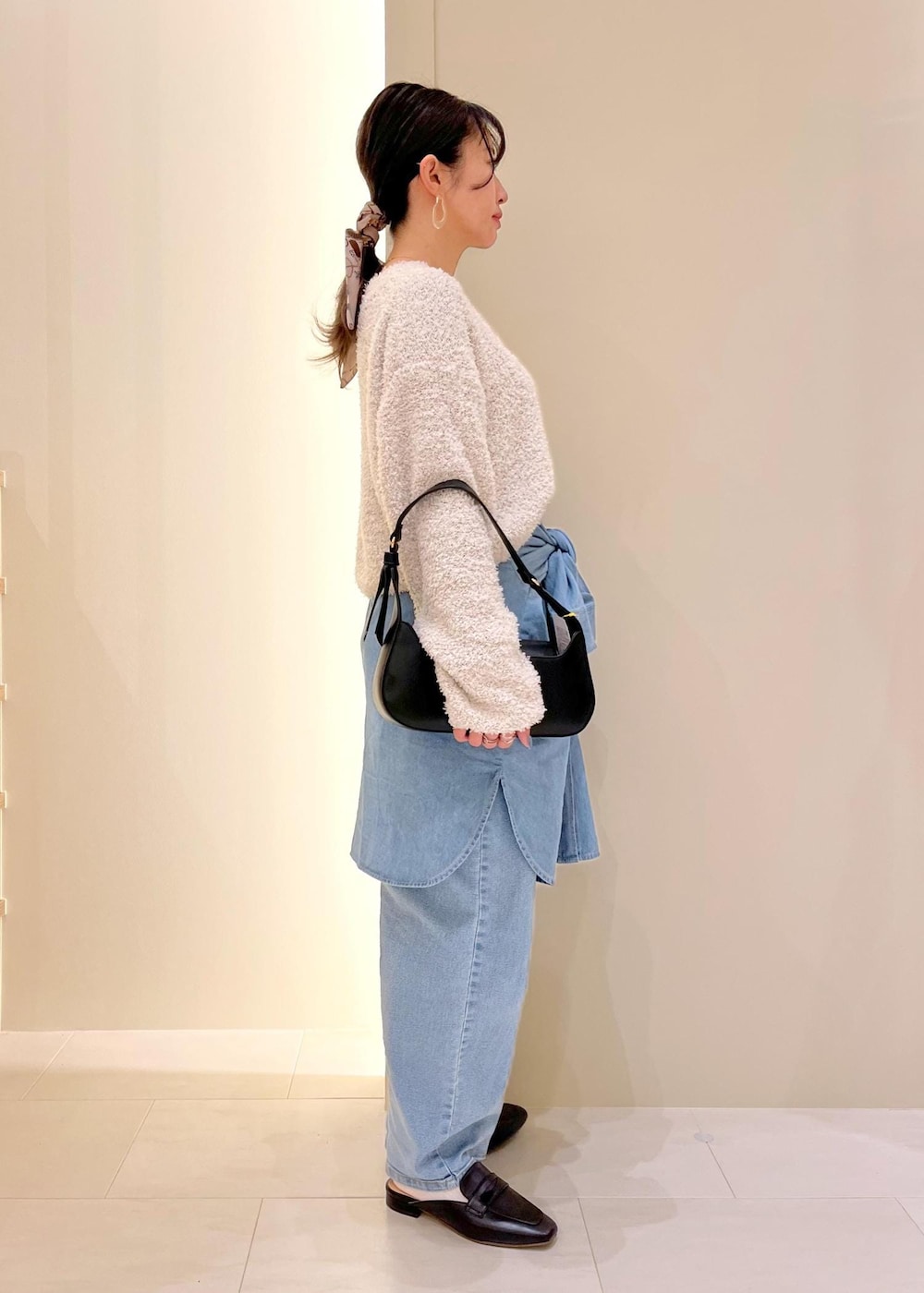 ブルー系のデニムパンツ、ブルー系のシャツ/ブラウス、グレー系のニット/セーターを着用したレディースの春コーディネートの3枚目の写真