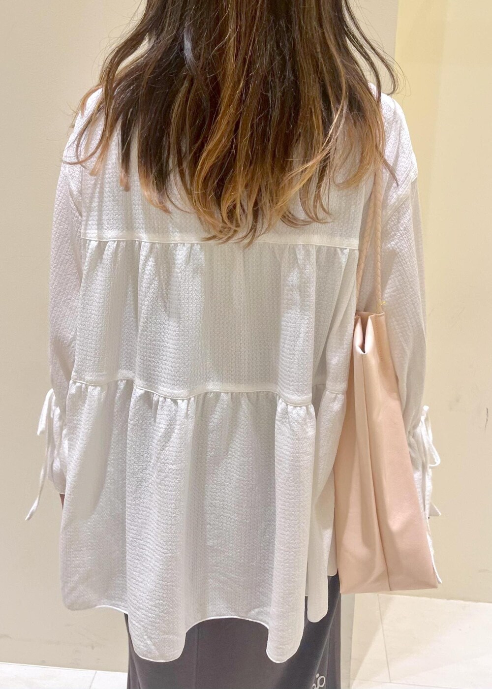 ピンク系のトートバッグ、ブラウン系のサンダル、ホワイト系のシャツ/ブラウスを着用したレディースの夏コーディネートの6枚目の写真