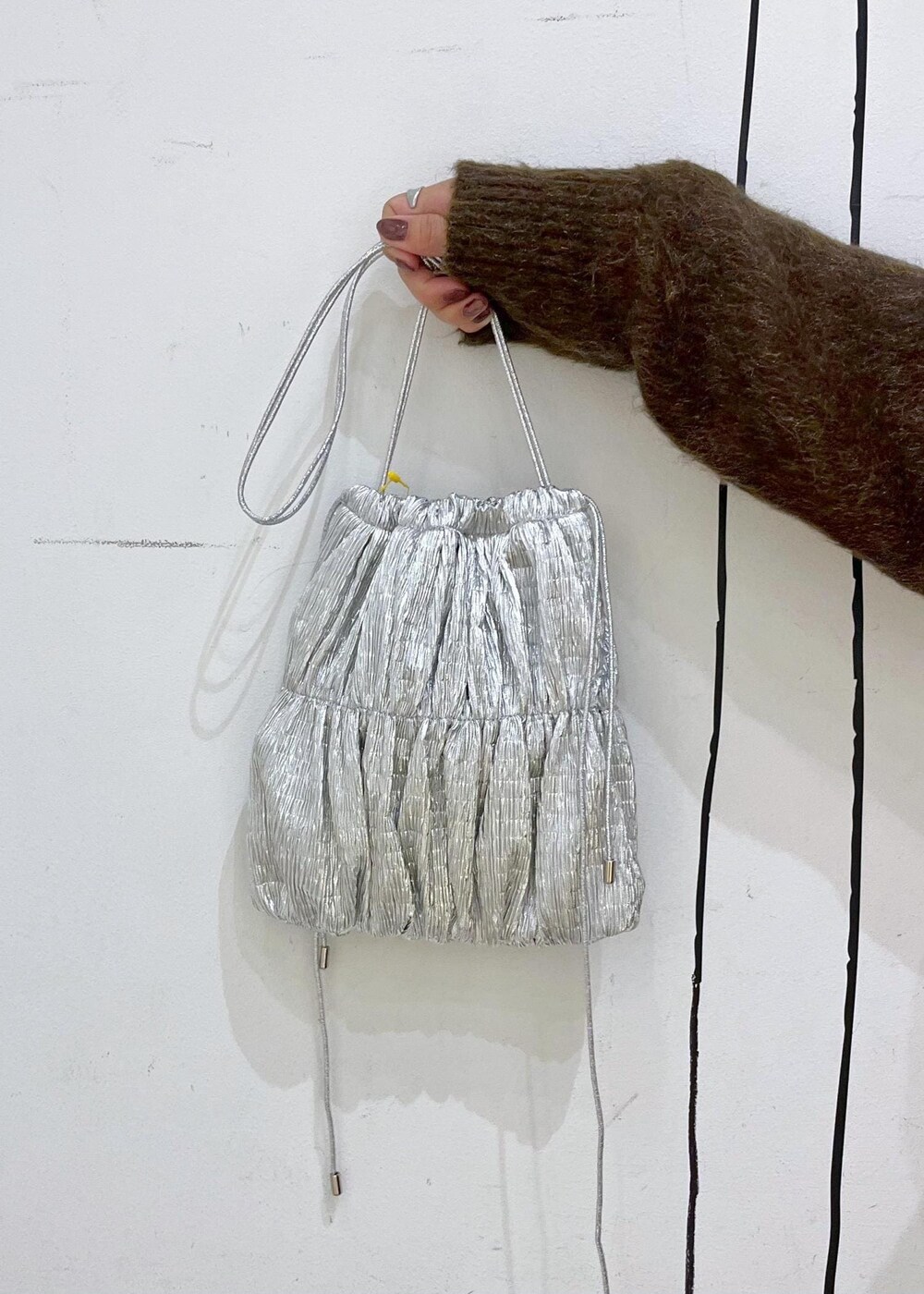 グレー系のカーゴパンツ、シルバー系のショルダーバッグ、ブラウン系のニット/セーターを着用したレディースの秋コーディネートの8枚目の写真