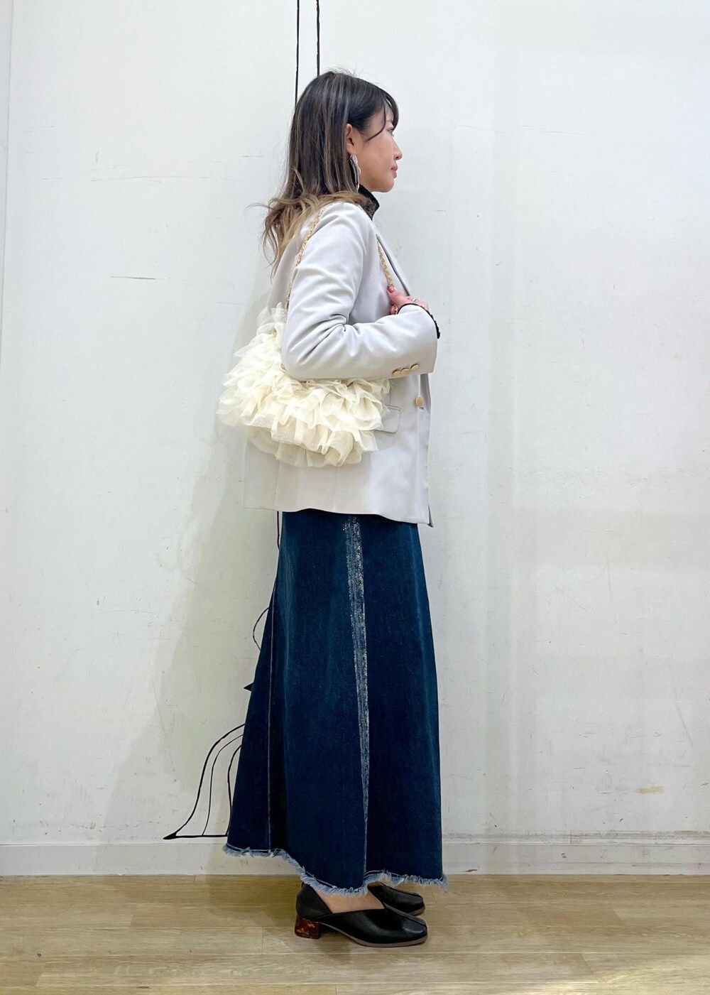 ブラック系のニット/セーター、ブラック系のニット/セーター、ブルー系のデニムスカートを着用したレディースの冬コーディネートの4枚目の写真