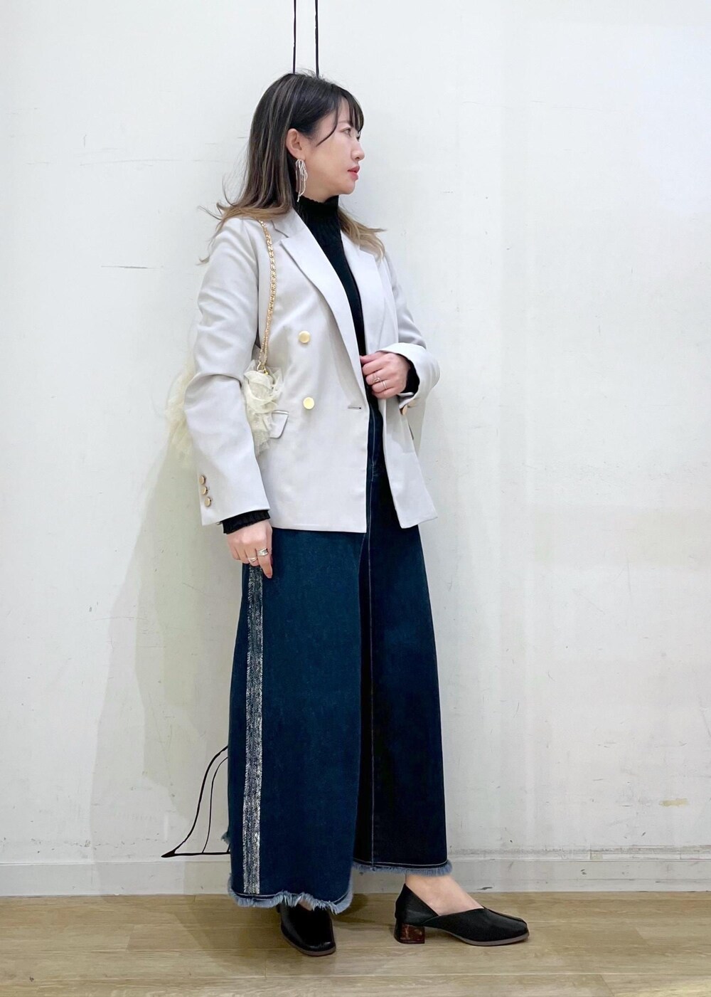 ブラック系のニット/セーター、ブラック系のニット/セーター、ブルー系のデニムスカートを着用したレディースの冬コーディネートの3枚目の写真