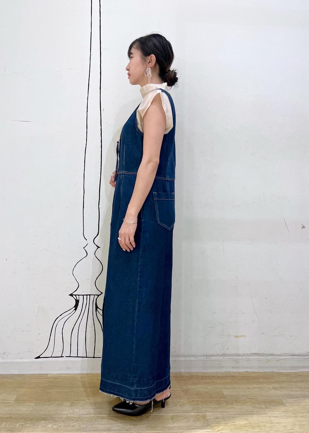 グレー系のタンクトップ、ブラック系のパンプス、ホワイト系のショルダーバッグを着用したレディースの夏コーディネートの3枚目の写真