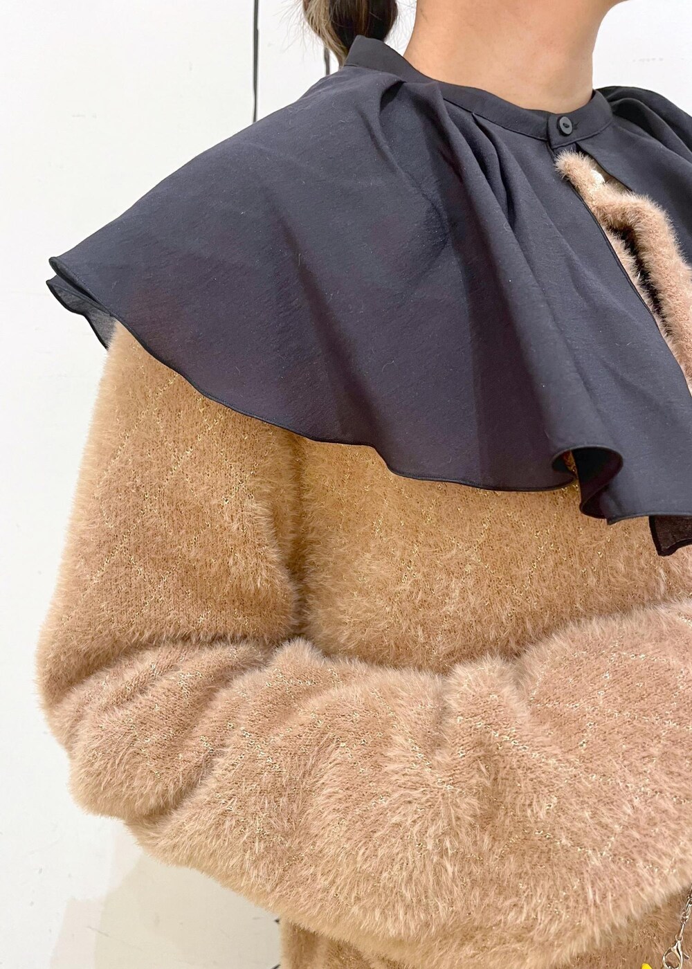 ブルー系のデニムパンツ、イエロー系のカーディガン/ボレロ、ホワイト系のショルダーバッグを着用したレディースの秋コーディネートの5枚目の写真