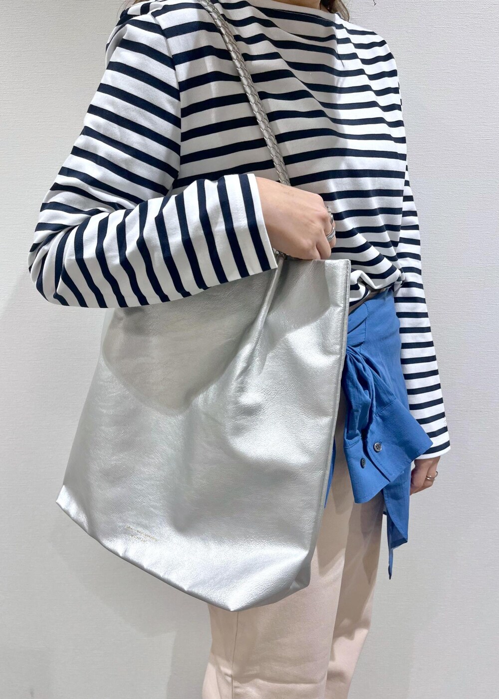 シルバー系のトートバッグ、シルバー系のトートバッグ、ブルー系のTシャツ/カットソーを着用したレディースの春コーディネートの4枚目の写真