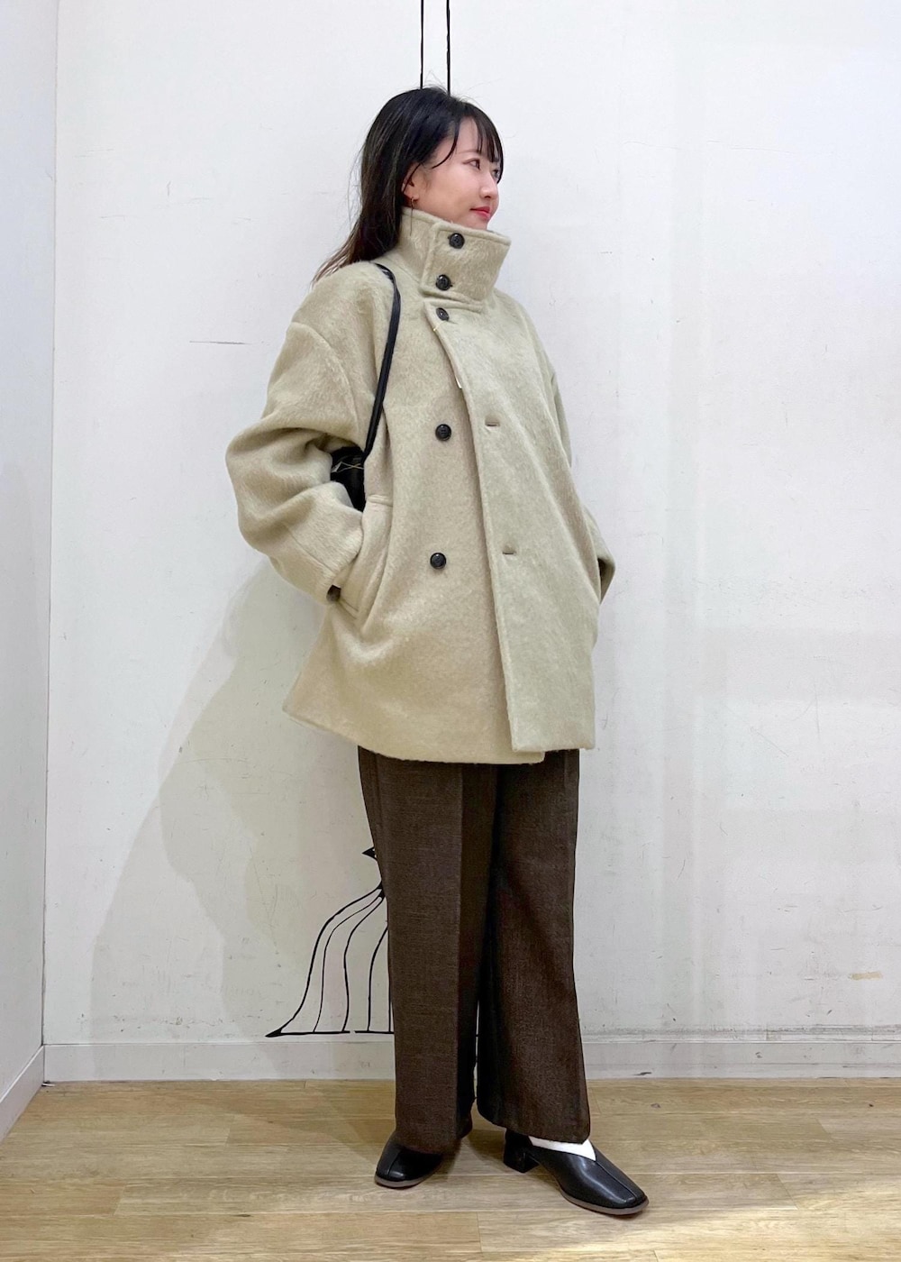 ホワイト系のニット/セーター、グリーン系のその他アウター、ブラウン系のその他パンツを着用したレディースの冬コーディネートの7枚目の写真