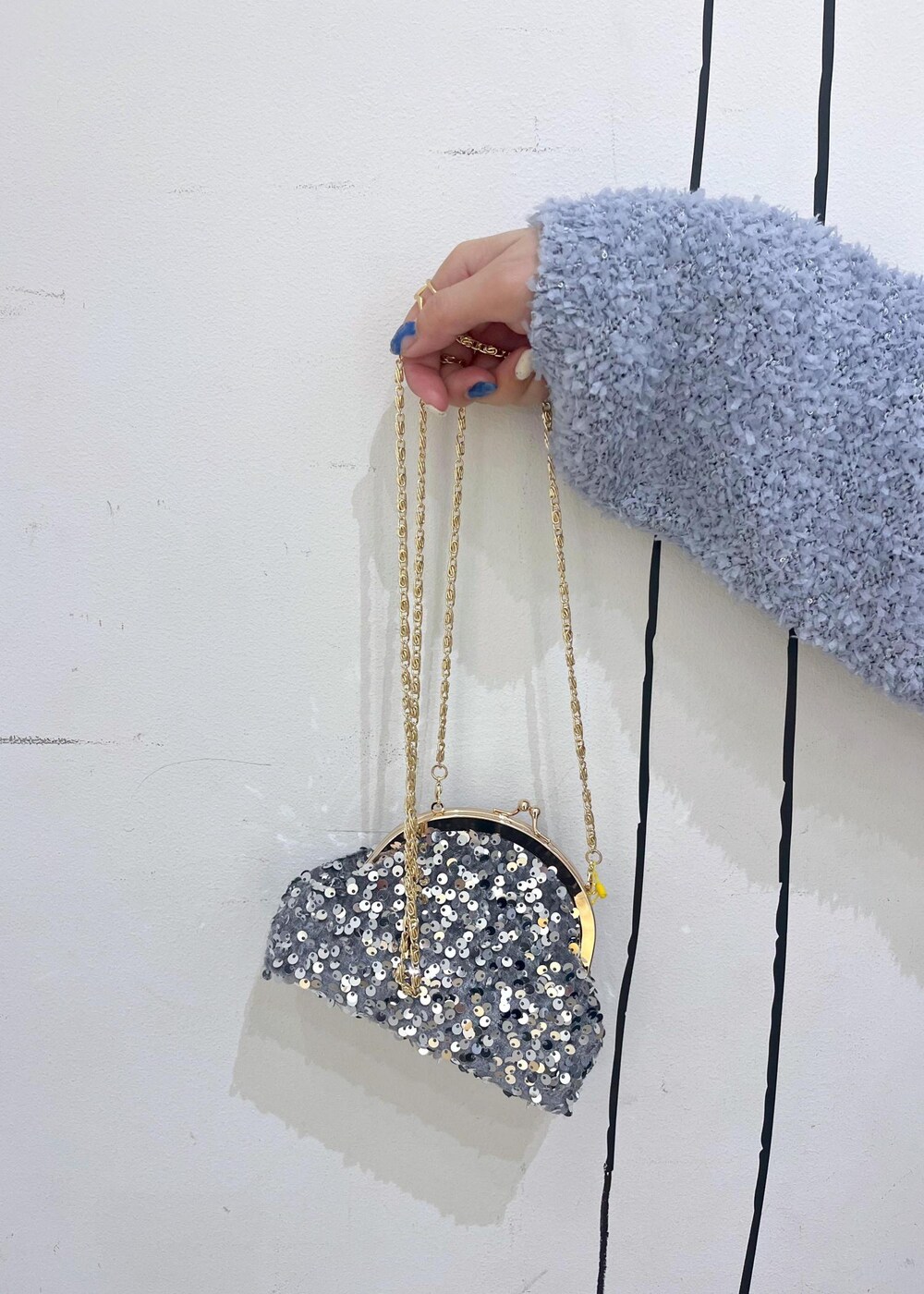 ブラック系のブーツ、グレー系のショルダーバッグ、ブルー系のデニムスカートを着用したレディースの冬コーディネートの9枚目の写真