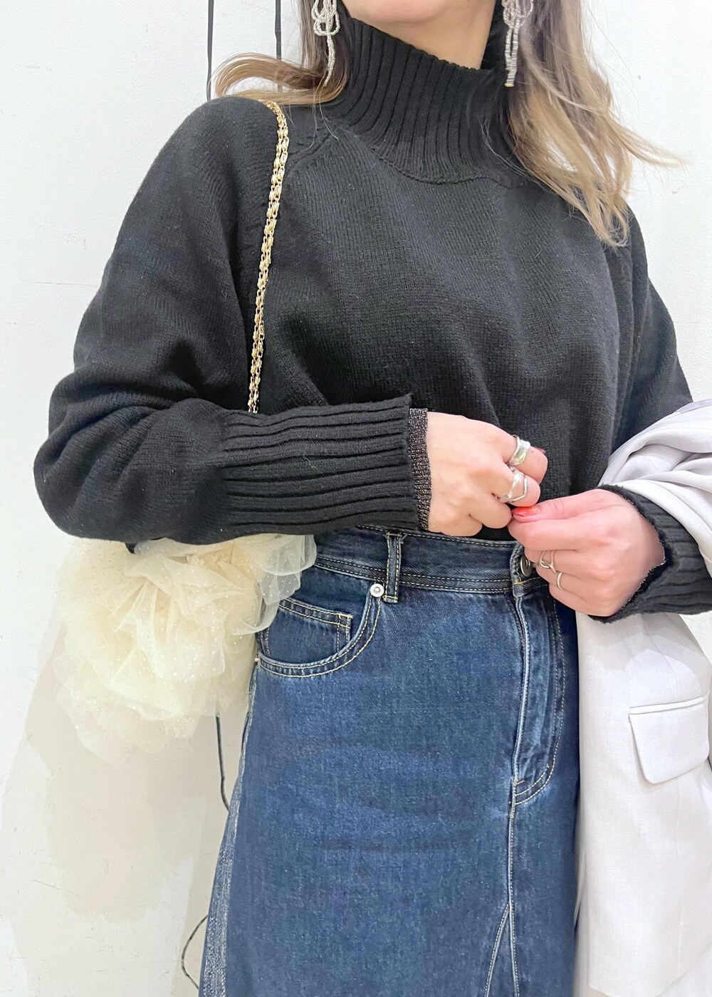 ブラック系のニット/セーター、ブラック系のニット/セーター、ブルー系のデニムスカートを着用したレディースの冬コーディネートの2枚目の写真