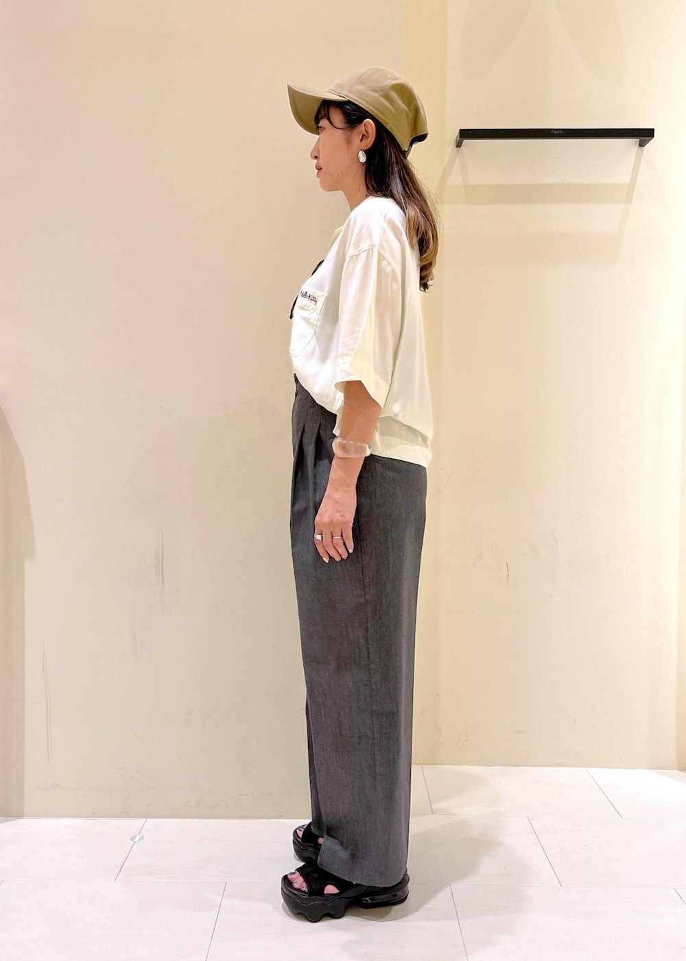 ピンク系のトートバッグ、グレー系のチノパンツ、ホワイト系のシャツ/ブラウスを着用したレディースの夏コーディネートの2枚目の写真